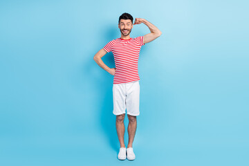 Fototapeta na wymiar Full length photo of powerful happy cheerful guy show biceps isolated on pastel blue color background