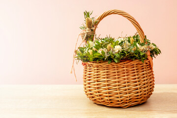 Fototapeta na wymiar A wicker basket with a bouquet of white bush roses and ornamental grass is on the table. Copy space