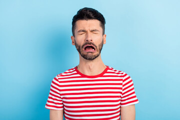 Photo of upset young man cry misery wear red striped t-shirt isolated on pastel blue color...