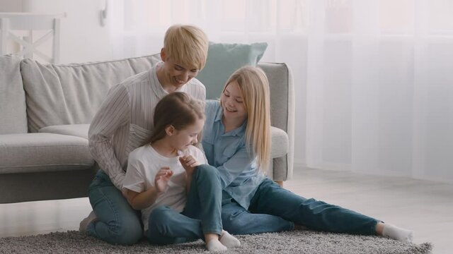 Happy Mom Tickling Daughters Having Fun At Home