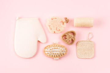 Natural hygiene products, wooden anti cellulite massager, loofah sponge, eco friendly, zero waste. Reusable items for beauty treatment from organic biodegradable material on pink background.