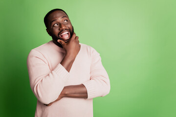 Photo of excited clever man finger chin look empty space wear white shirt over green background
