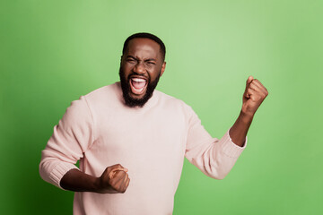 Photo of excited man rejoice scream raise hands wear white shirt over green background
