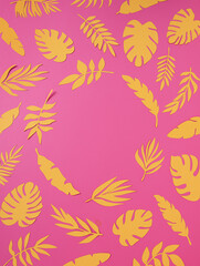 Fototapeta na wymiar Natural tropical frame with yellow paper palm leaves on pink background. Minimal summer exotic texture concept with copy space for text. Flat lay, top view.