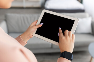 Woman using digital tablet with blank empty screen, mockup