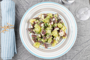 Octopus and potato salad on white plate