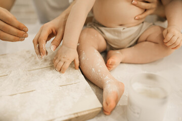 Obraz na płótnie Canvas The bare legs of a small child in flour