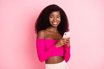 Fototapeta na wymiar Photo of nice optimistic brunette hairdo lady hold telephone wear bright top isolated on pink color background