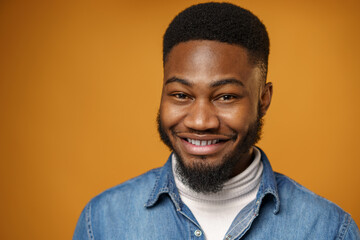 Portrait of young handsome african american guy against yellow background