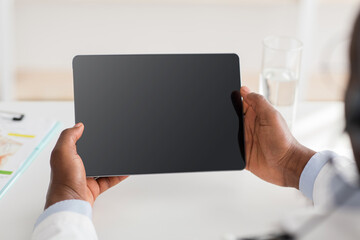 Remote medical consultancy. African american doctor consulting patient via web conference on digital tablet.