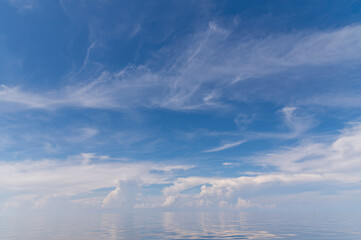 Blue sky and white fluffy clouds with reflect on sea background and pattern