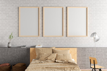 Three vertical blank poster frames mock up on the white brick wall in interior of loft bedroom.