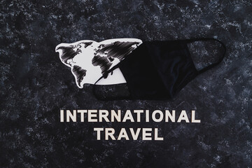 world map with International Travel text and face mask,  travel industry after the covid-19 pandemic