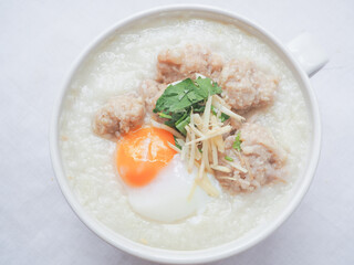 Top view of Rice porridge with minced pork, soft-boiled egg, sliced ginger