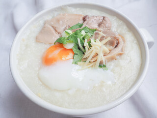 Top view of Rice porridge with pork offal, soft-boiled egg, sliced ginger