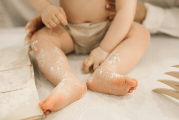 The bare legs of a small child in flour