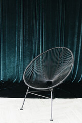 Details of the stylish interior with a vintage chair on the background of emerald velvet fabric