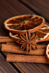 Close up Cinnamon sticks, star anise and dried orange on a wooden background. Spices for making mulled wine or masala tea.