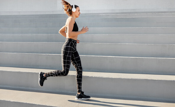 Horizontal image fit young woman running along concrete stand stairs motion blur