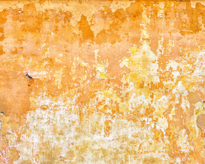 Old vintage paper in sepia color. The surface of crumbling plaster with a cracked texture and old bright yellow paint on the facade of the house.
