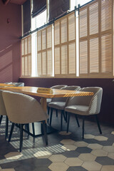 The interior of a cozy cafe. Beautiful shadows on the floor and on the table. Sunny day. Vertical photo