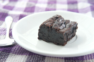 slice of homemade brownie on plate on table 