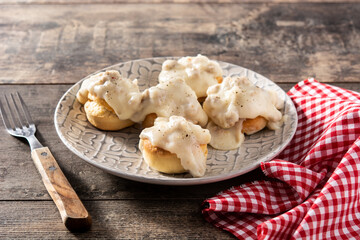 Traditional American biscuits and gravy for breakfast on wooden table