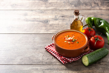 Gazpacho soup in crock pot and ingredient on wooden table