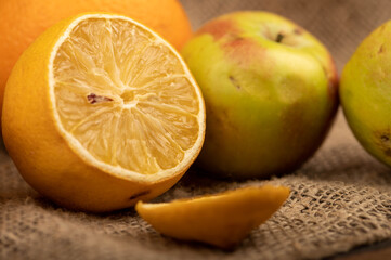 Obraz na płótnie Canvas Sliced lemon and fresh green apples on a homespun cloth with a rough texture.