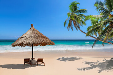 Tropical beach with coco palms and sun umbrella, beach sunbeds, turquoise sea in tropical island. 