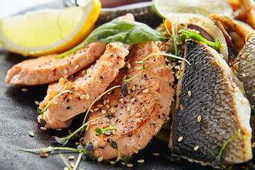 Teppanyaki Style Seafood - Grilled Mixed Seafood with Soy Sauce and Vegetables. Japanese Teppanyaki Salmon Steak, Shrimp, Scallop and Fish Fillet garnished with lemon and green salad.