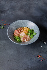 Vietnamese Cuisine - Beef Pho Noodle Soup or Pho Bo Soup. Served with Fresh Greens in Blue Bowl on...