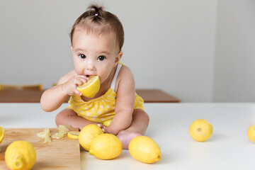 Cute baby girl biting in a lemon