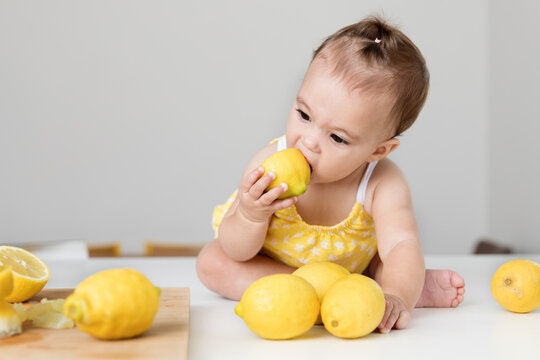 Baby girl biting in a lemon