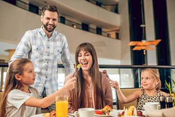 Smiling family sitting at the table and having fun