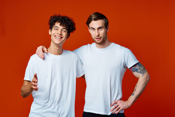 Two cheerful friends in white t-shirts stand side by side