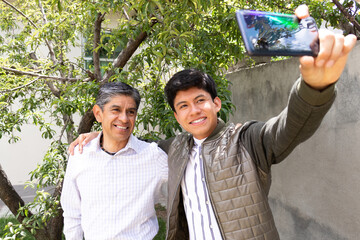 father and son smile as they take a selfie together