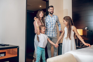 Young sweet family standing in the room and looking excited