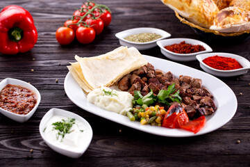 Assorted Middle Eastern and arabic dishes on a dark rustic background. Hummus, tabbouleh, pita, meat kebab, falafel, baklava. Halal food. Top view. Turkish foods, Turkish pizza, Turkish breakfast
