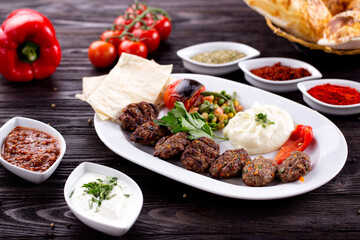 Assorted Middle Eastern and arabic dishes on a dark rustic background. Hummus, tabbouleh, pita, meat kebab, falafel, baklava. Halal food. Top view. Turkish foods, Turkish pizza, Turkish breakfast