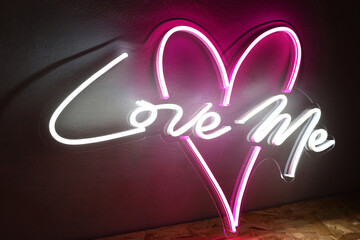 White and pink neon heart with the inscription love me. Trendy style. Wedding design.  Neon sign....
