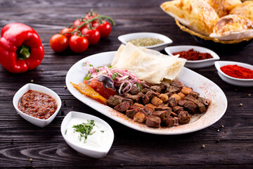 Assorted Middle Eastern and arabic dishes on a dark rustic background. Hummus, tabbouleh, pita, meat kebab, falafel, baklava. Halal food. Top view. Turkish foods, Turkish pizza, Turkish breakfast