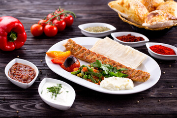 Assorted Middle Eastern and arabic dishes on a dark rustic background. Hummus, tabbouleh, pita, meat kebab, falafel, baklava. Halal food. Top view. Turkish foods, Turkish pizza, Turkish breakfast