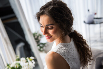 young nice girl in a white dress is watching on a side 