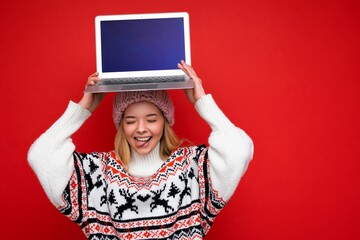 Photo shot of beautiful smiling blonde young woman holding computer laptop with empty monitor...
