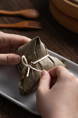 Eating zongzi rice dumpling for Dragon Boat Festival celebration.