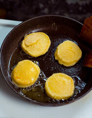 cooking small pancakes with delicious natural egg filling with cottage cheese, fry them in a pan and serve on a plate