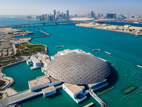 Abu Dhabi, United Arab Emirates - April 6, 2021: Louvre museum and Abu Dhabi aerial emirate skyline in the UAE capital