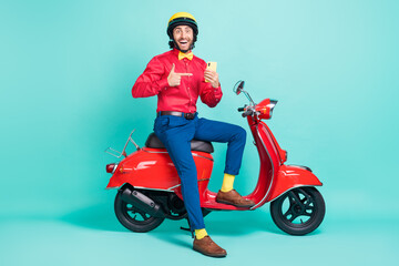Fototapeta na wymiar Full size photo of happy excited man in helmet recommend phone sit moped isolated on turquoise color background