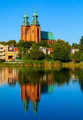 Fototapeta na wymiar Cathedral of Virgin Mary Assumption and St. Wojciech at Lech Hill across Jelonek Lake in old town historic city center of Gniezno in Grater Poland